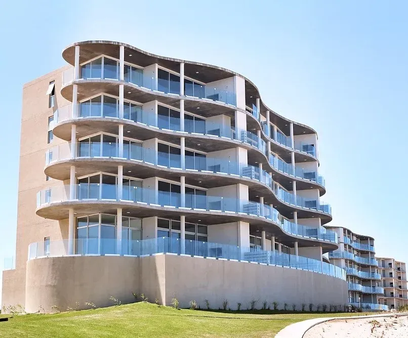 Edificio terminado de NorthBeach frente al mar, con arquitectura de balcones curvos