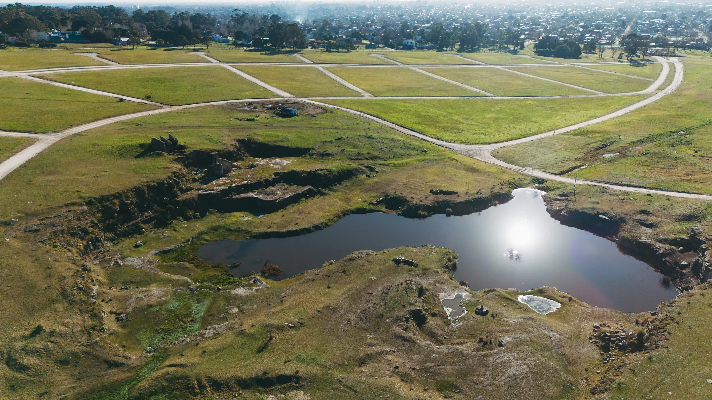Vista aérea real de la laguna de la cantera en Santa Celina, con luz de atardecer sobre el agua