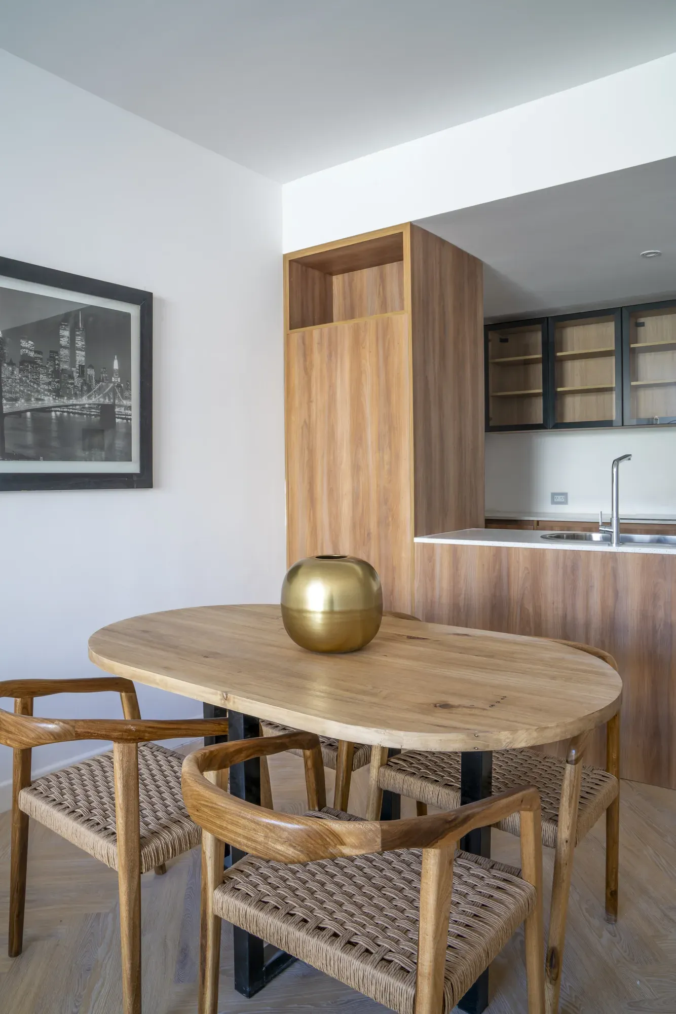 Comedor real de una unidad de Village Design, con mesa de madera y cocina integrada