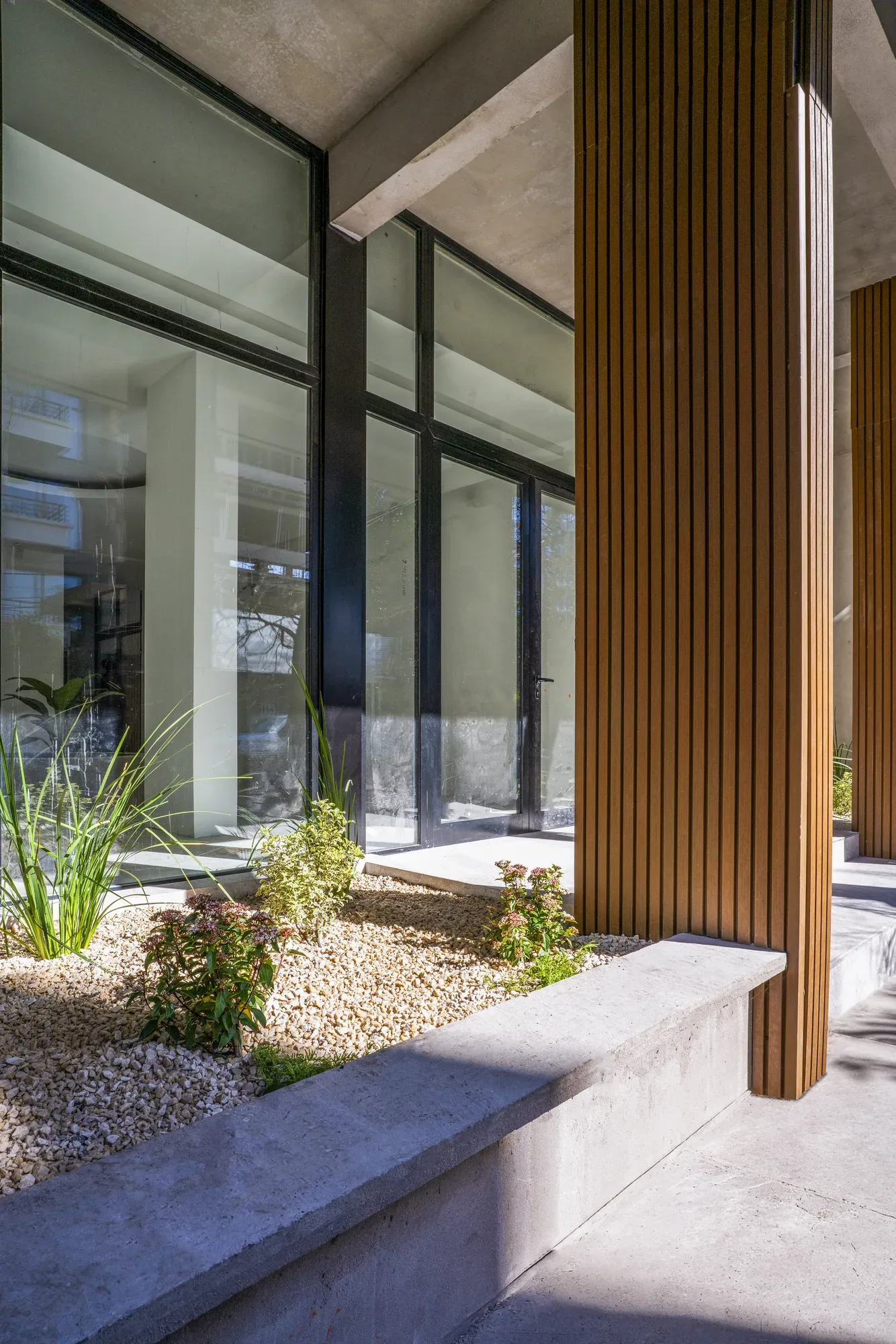 Detalle real del acceso de Village Design, con columnas de listones de madera